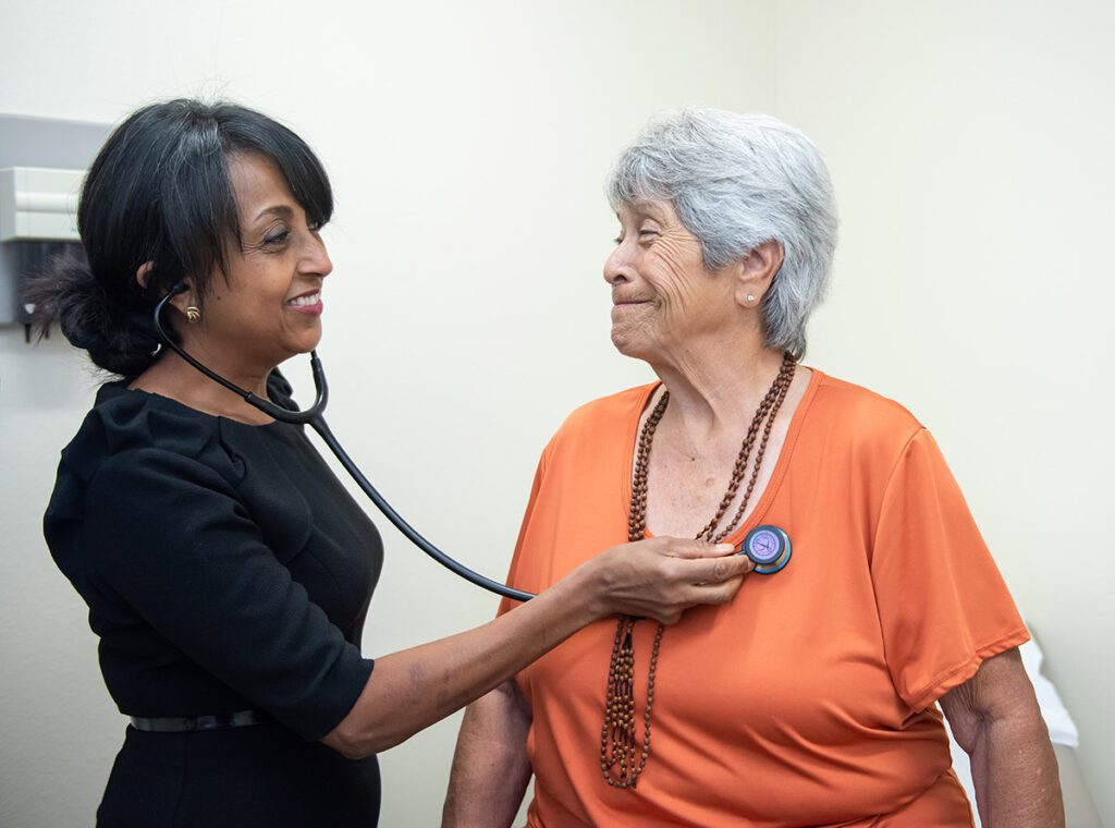 A doctor examines a patient's heart by using a stethoscope.