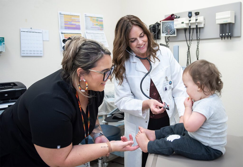 A doctor and nurse examining a toddler.